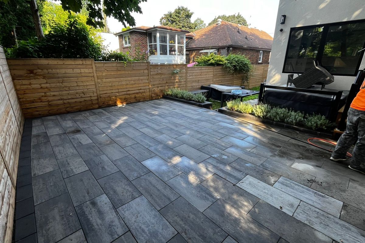 Backyard paver patio beside a cedar privacy fence